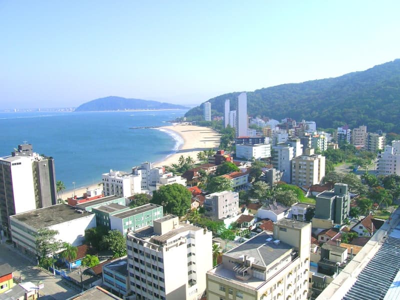 Curva costeira panorâmica integrando os balneários de Matinhos e Caiobá com vegetação e mar