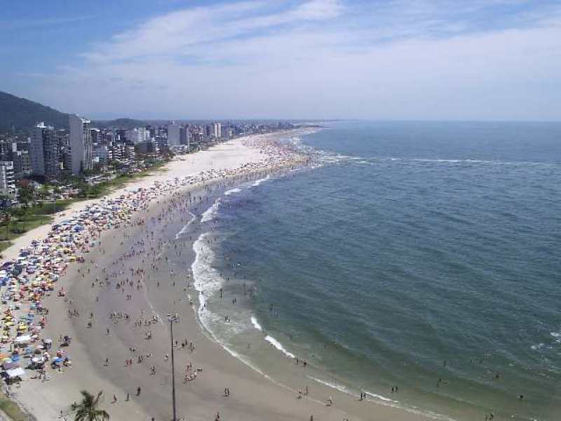 Vista aérea oblíqua da praia urbana com faixa de areia e mar aberto